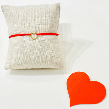 Bracelet Amore collection Gris Bijoux
Coeur en plaqué or monté sur son Cordon rouge en coton 
Bracelet ajustable