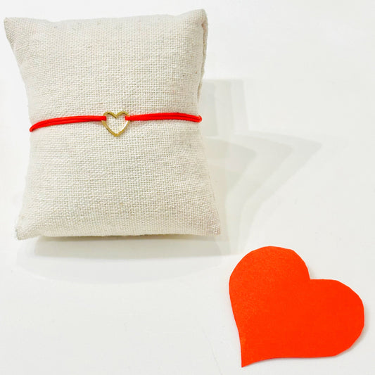 Bracelet Amore collection Gris Bijoux
Coeur en plaqué or monté sur son Cordon rouge en coton 
Bracelet ajustable
