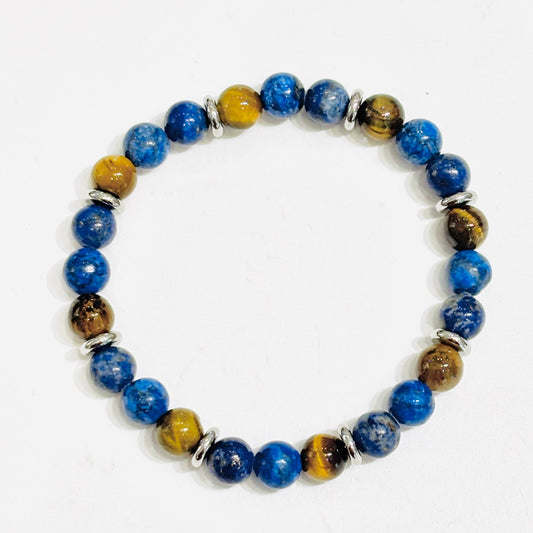 Lumineux et élégant, le bracelet Léo de la collection Gris Bijoux se compose de pierres naturelles telles que le lapis-lazuli au coloris bleu intense et l'œil de Tigre aux nuances brunes. Ses détails en acier inoxydable argentés ajoutent une touche chic au modèle.

Acier inoxydable, lapis lazuli et œil de tigre
Lapis Lazuli : réduit le stress et l'anxiété
Œil de Tigre : apporte protection et force
Résiste bien à l'eau, garanti 1 an
Garanti sans nickel et sans risque d'allergie

Livré dans un joli pochon