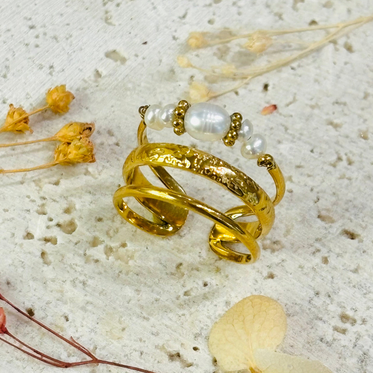 Bague Poema
Effet triple anneau
détails perles imitation
acier inoxydable doré