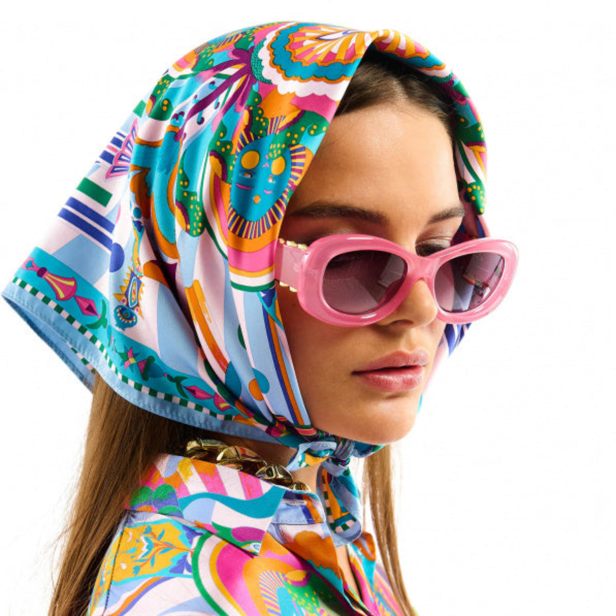 Baigné dans un univers fantasmagorique et hallucinogène, ENCHANTERED se pare en son centre d'un œil façon pentacle autour duquel quatre soleils aux visages poupons viennent se dessiner. Dans cette même veine, le reste du foulard raconte un monde à part, à la frontière de l'inconscient et d'un imaginaire débridé et coloré, sur fond de larges rayures empruntées à l'esthétique des années 70. Décliné en deux couleurs, ENCHANTERED est ici dans sa version bleue et se révèle dans des tons orange corail, rose 